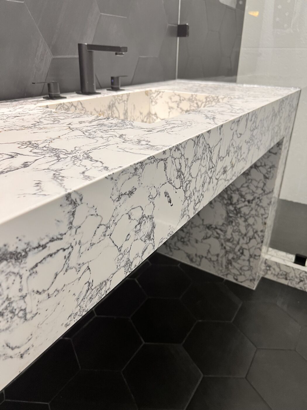 Waterfall vanity edge over hex tile