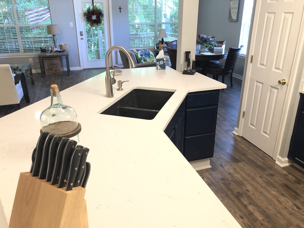 Island with a prep sink and dark base cabinets