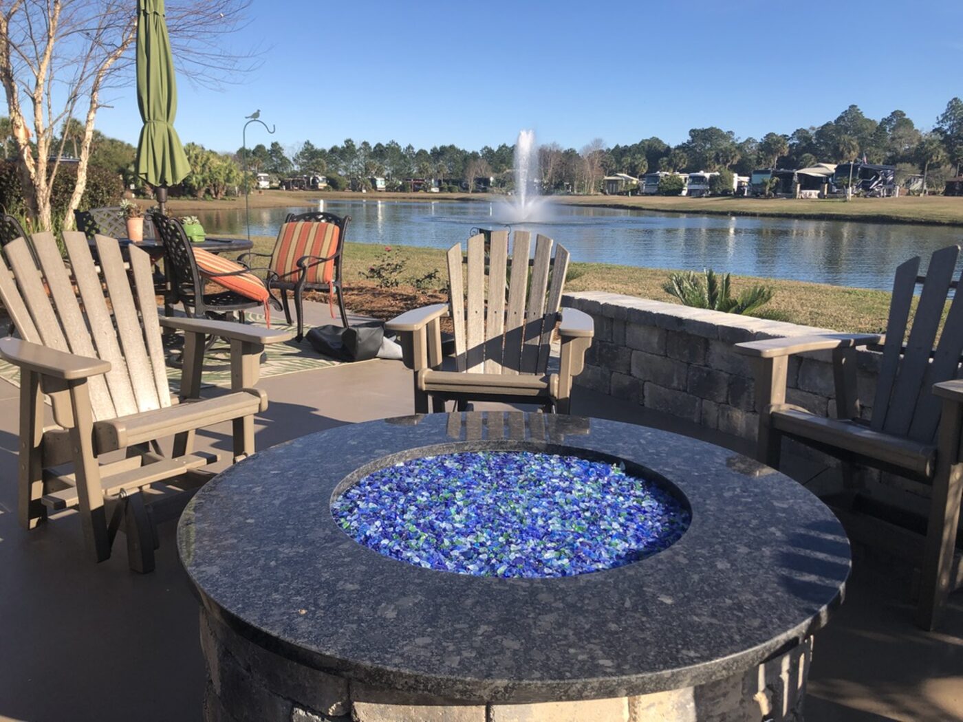 Fire pit table topped in granite at the water edge