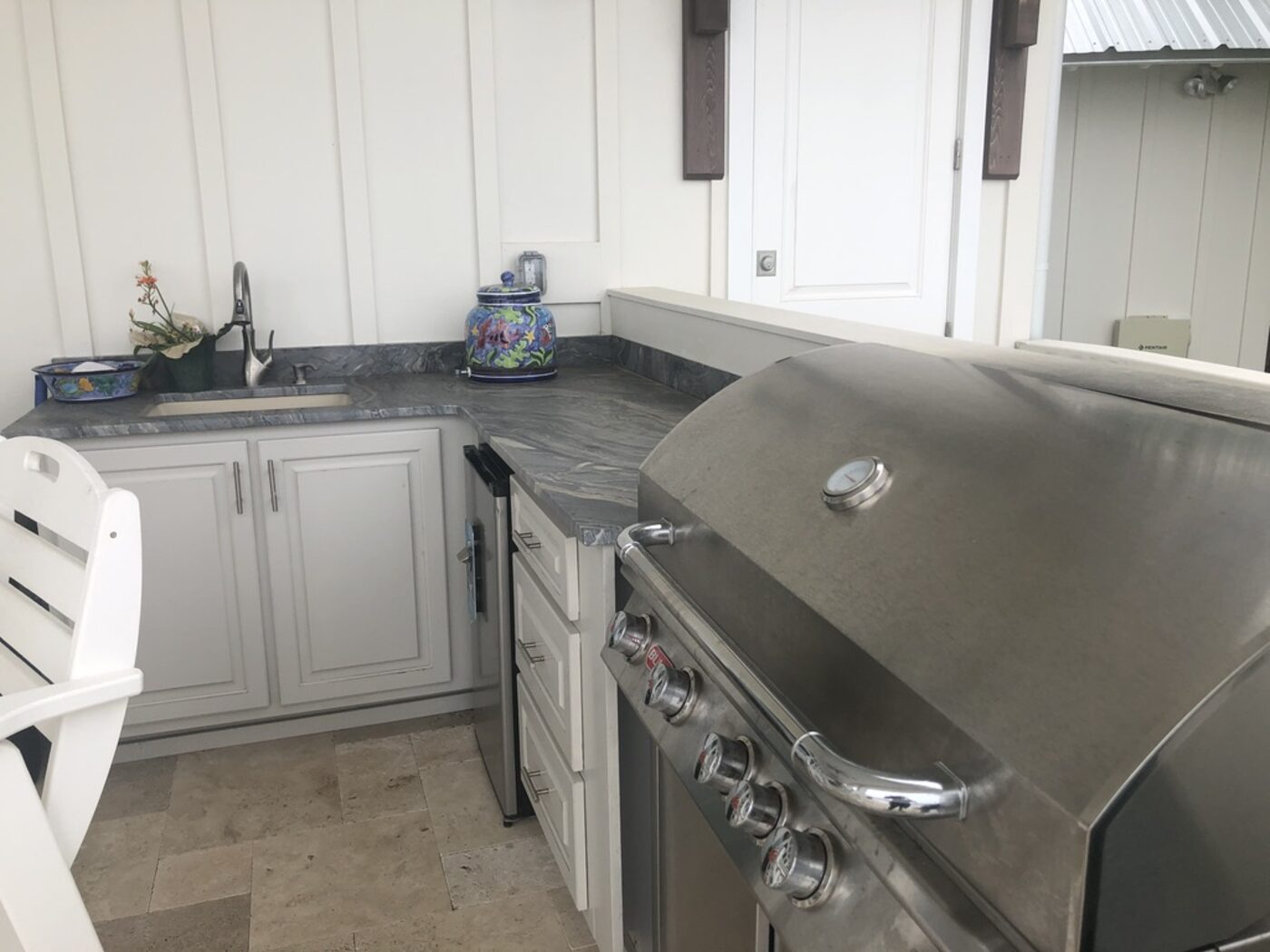 Grill station with a dark granite counter and prep sink