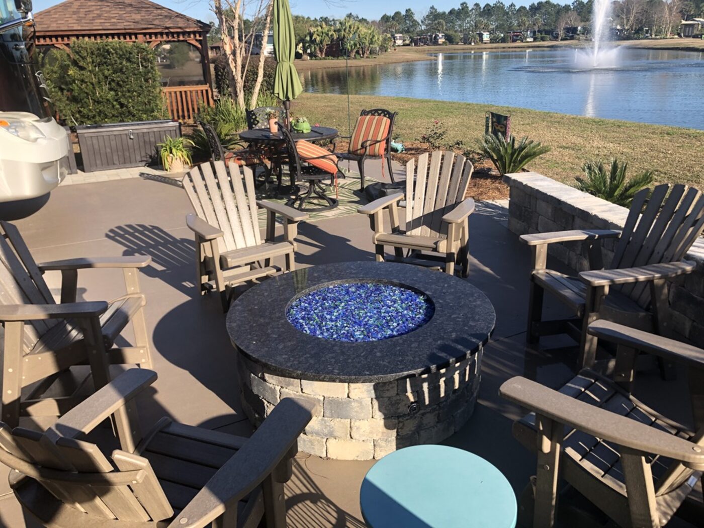 Patio seating around a granite topped fire pit table on the lake